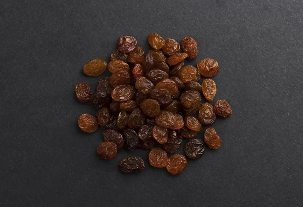 Pile of dried raisins on black background — Stockfoto
