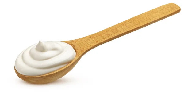 在白色背景上隔离的木制勺子中倒入奶油 — 图库照片