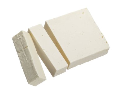 Yunan fetası. Kesme yolu ile beyaz arkaplanda izole edilmiş dilimlenmiş yumuşak peynir