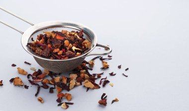 Çay süzgeci ile çay yaprakları, meyve ve böğürtlen
