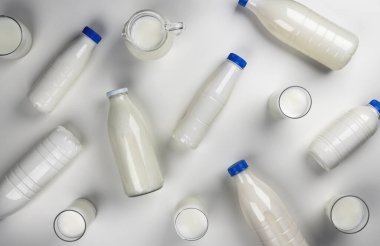 Süt ürünleri ambalajı, beyaz arka planda süt bulunan şişeler ve bardaklar, üst görünüm
