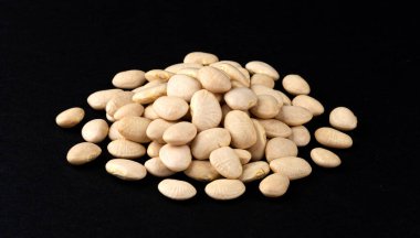 Siyah arkaplanda izole edilmiş beyaz fasulye yığını.