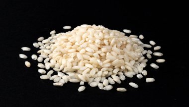 Siyah arka planda izole edilmiş bir yığın risotto pilavı, yakın plan.