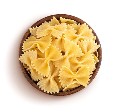 Beyaz arka planda izole edilmiş ahşap kasede çiğ farfalle makarna.