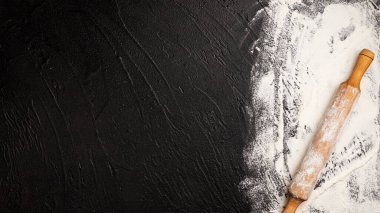 Siyah zemin üzerine serpiştirilmiş buğday unu ve ahşap raptiye, metin için metin alanı ile birlikte afiş pişirme