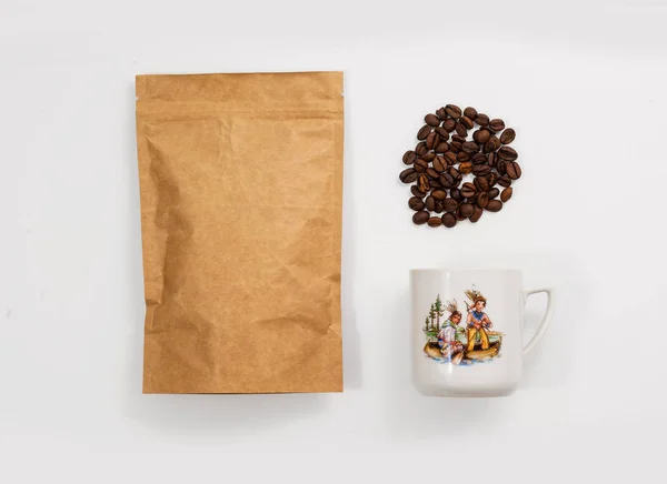 Vintage cup of coffee on white, pack coffee and coffee grains. Hipster background.