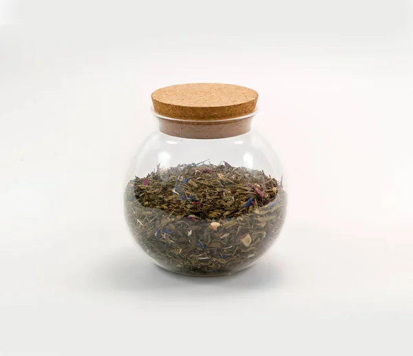 Round glass jar with a cork filled with aromatic tea with dried — Stock Photo, Image