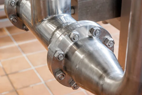 Connection of stainless steel pipes with bolts. Brilliant surfac