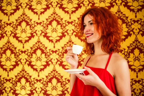 Hermosa chica con el pelo rojo está sosteniendo una taza de espresso en su — Foto de Stock