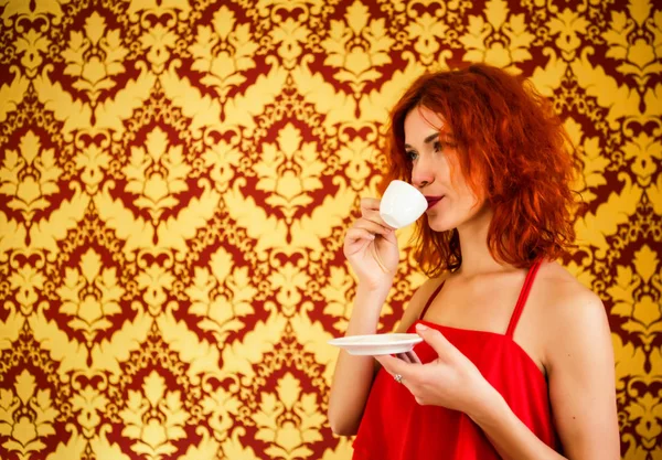 Hermosa chica con el pelo rojo está sosteniendo una taza de espresso en su — Foto de Stock