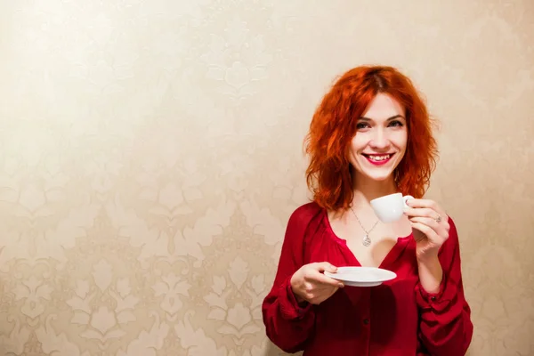 Hermosa chica con el pelo rojo está sosteniendo una taza de espresso en su — Foto de Stock