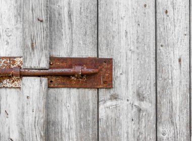 Eski ahşap kapı ambar. Kapalı paslı metal civatalar