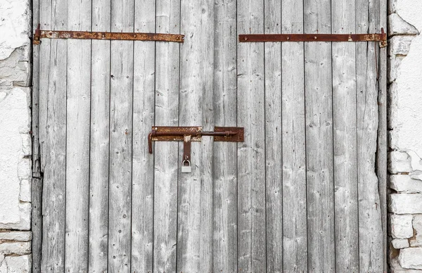 Old wooden gate warehouse. Closed on rusty metallic bolts — Stock Photo, Image
