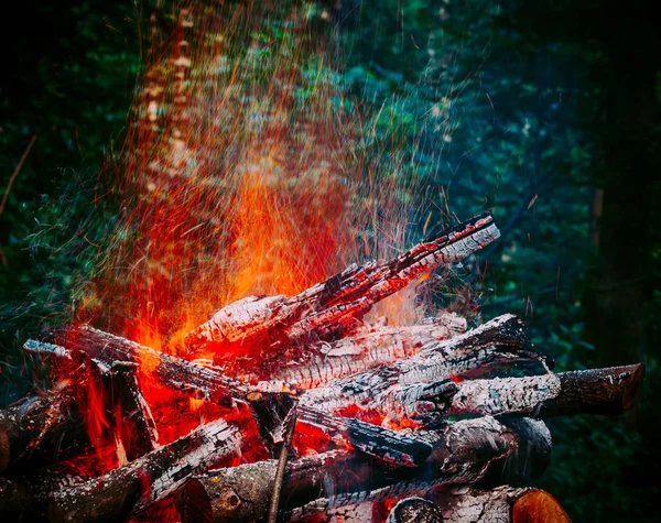 Vreugdevuur in het bos in de natuur. Sporen van sparks. Tonale correcti — Stockfoto