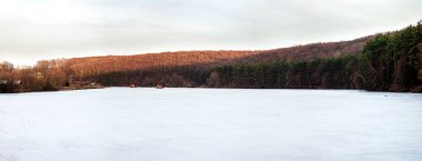 küçük bir göl buz, orman kenarı, gün batımı ile kaplı