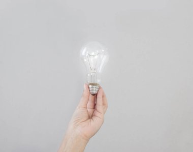 Kadın eli bunları elektrik bir ampul tutar. Oluşturma bir