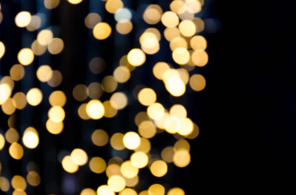 Yellow gold lights, garlands. Blurred photo. Celebratory background. — Stock Photo, Image