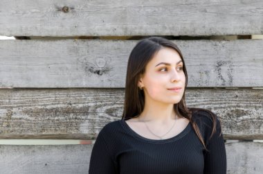 Bir duvar arka plan gri kurulların kaba kesme güzel bir genç esmer kız portresi.