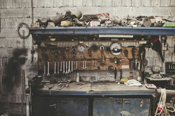 Старый металлический стол в металлическом цехе, заполненном инструментами — стоковое фото