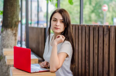 Sokak bir kafede bir masada oturan kırmızı la ile güzel kız