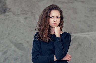 Baştan çıkarıcı güzel kıvırcık kız, gri arka planda portre