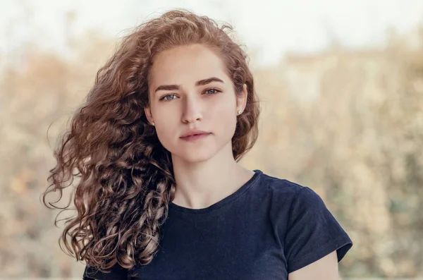 Cabello rizado. Chica alegre sobre un fondo de hojas amarillas retrato de otoño — Foto de Stock