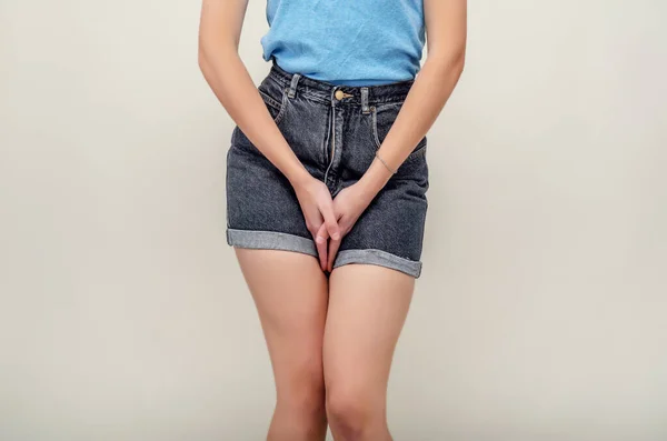 Mujer joven en pantalones cortos y un sujetador está experimentando dolor en el útero, presionó las manos hacia la parte inferior del abdomen. Concepto médico. Problemas ginecológicos . —  Fotos de Stock