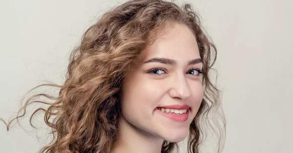 Retrato de menina bonita, close-up. Cabelo encaracolado. A brincar aos cabelos. Sorriso sedutor — Fotografia de Stock