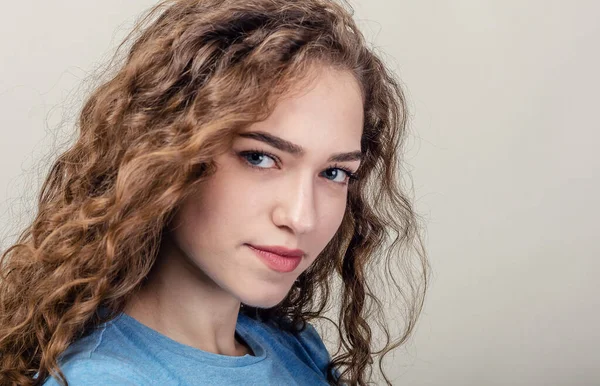 Retrato de una joven hermosa, primer plano. Cabello rizado. Jugando al pelo. Sonrisa seductora — Foto de Stock