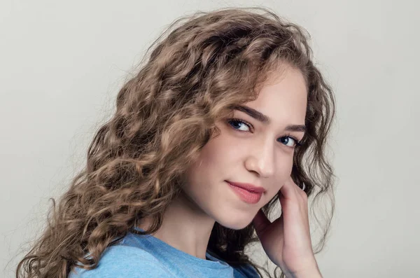 Retrato de una joven hermosa, primer plano. Cabello rizado. Jugando al pelo. Sonrisa seductora — Foto de Stock