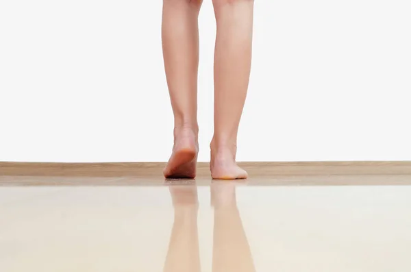 Frauenbeine laufen auf warmem Boden aus hellgelben Fliesen — Stockfoto