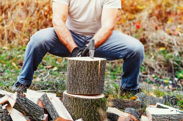 Hombre cortando madera con un hacha, partes de troncos se dispersan a los lados —  Fotos de Stock