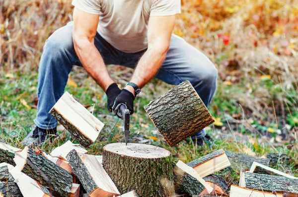 Hombre con manos fuertes cortando madera con un hacha piezas volar aparte —  Fotos de Stock