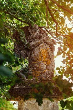 Dallar arasındaki azizin harap olmuş heykeli..