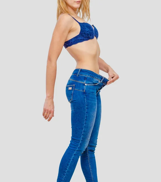 Woman shows weight loss in old big jeans — 스톡 사진