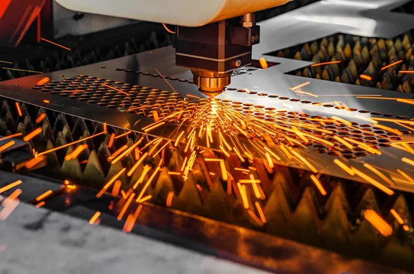 Metal lazer kesme makinesi. Lazer kafa çarşafı kirişle keser, kıvılcımlar farklı yönlere dağılır.