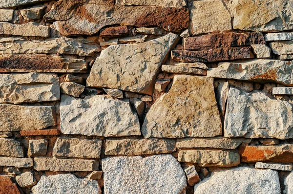 Pared hecha de piedras viejas de diferentes tamaños —  Fotos de Stock