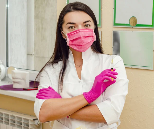 Доктор жінка в медичній масці з шприцом в руці — стокове фото