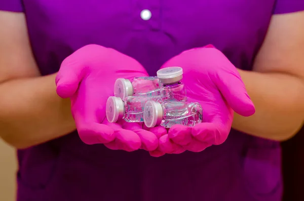 Las manos en guantes de goma sostienen ampollas de vidrio con medicamentos . —  Fotos de Stock