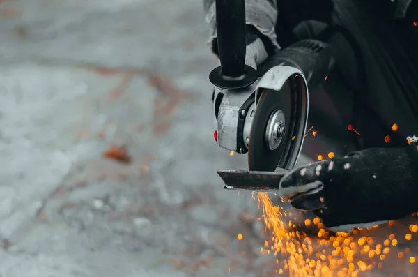 Arbeiter schneidet mit einer elektrischen Kreissäge eine Metallplatte. verschwommen — Stockfoto