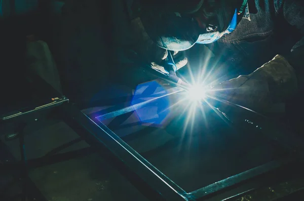Συγκόλληση ενός μεταλλικού προϊόντος σε εργαστήριο μετάλλων. Φωτεινή λάμψη ενός ηλεκτρικού τόξου. Κατασκευή μεταλλικών στηριγμάτων — Φωτογραφία Αρχείου