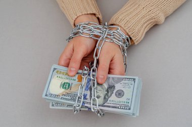Çelik zincirli kadın elleri kağıt dolarlar tutar..