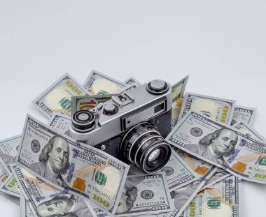 Dağınık Amerikan dolarları üzerinde klasik film kamerası. Fotoğraf stoklarından kazanç kavramı.