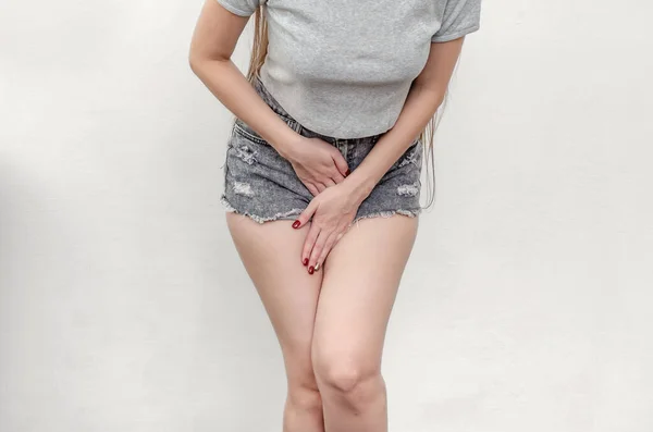 穿着短裤和T恤衫的年轻女性正经历子宫疼痛 双手插在下腹 医学概念 妇科问题 — 图库照片