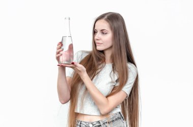 Elinde şeffaf cam şişeyle güzel bir kız.