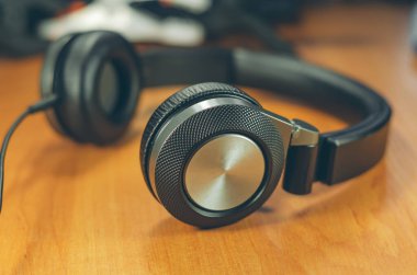 Ahşap masa arkasında siyah kulaklıklar..