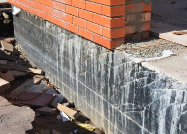 Temel su yalıtımı. Temel su yalıtımı ve Dampproofing kaplama. House foundation tar sprey ile su yalıtımı. Bodrum ve temel su yalıtımı için yapım teknikleri