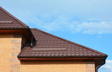 Yeni ev yağmur ile çatı oluk su yalıtımı. Boru bağlantı parçaları guttering aşağı. Evin çatı oluk sistemi ve çatı koruma kar Kurulu (kar guard) yağmur.