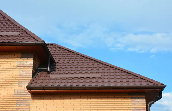 Takläggning med nya hus regn Gutter tätskikt. Guttering ner rördelar. Regn gutter system och tak skydd från snow board (snörasskydd) på huset tak. — Stockfoto