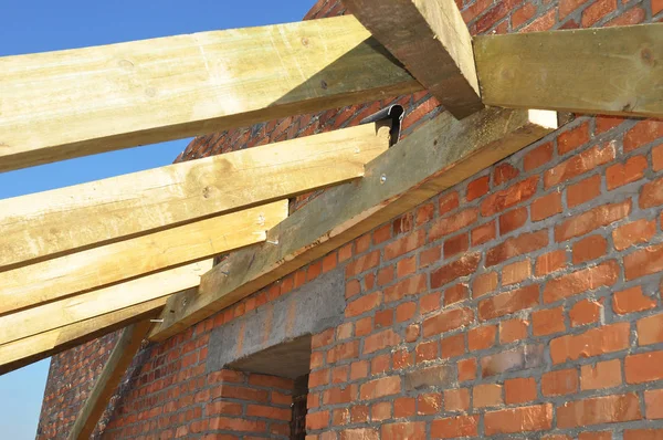 Close up on installation of wooden beams at construction the roof truss system of the house. Roofing Construction. — Stock Photo, Image